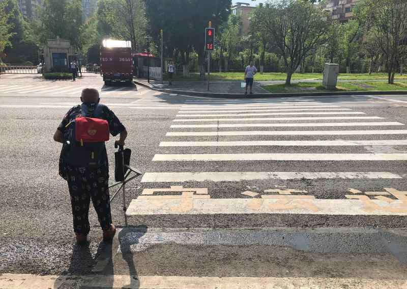 万里长江横渡下一句 80岁残疾老人顶40度高温背着书包，单程5小时，到底去做什么？
