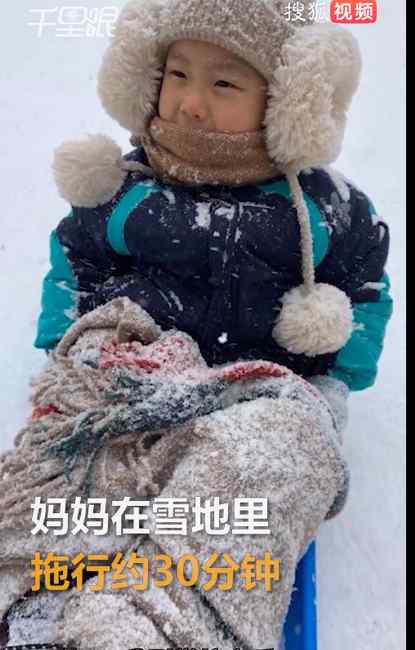 萌娃为拿全勤奖坚持冒雪上学 妈妈用雪板拖行送上学 头发结冰