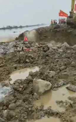 安徽庐江河堤上出现50米决口 大型挖掘机被洪水卷走