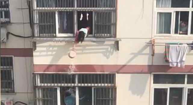 江苏一名住户站在自家窗口眺望，结果意外拍下对面楼两名女子“泼水大战”奇葩画面，现场让人哭笑