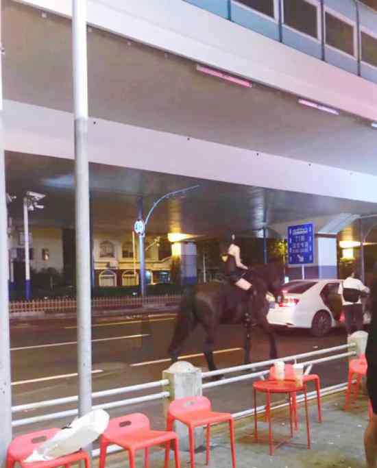 女子深夜骑马 吊带衫女子深夜骑马穿行上海市中心，警方已介入调查