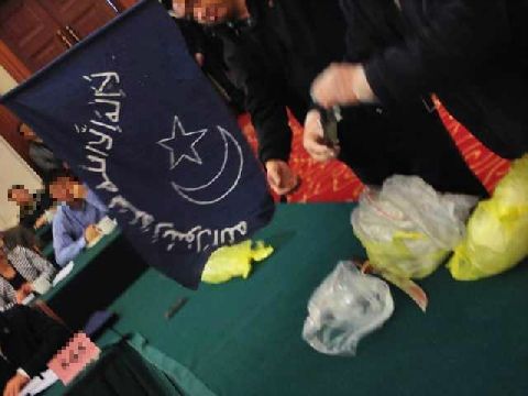 警方展示搜出的疆独分子旗帜