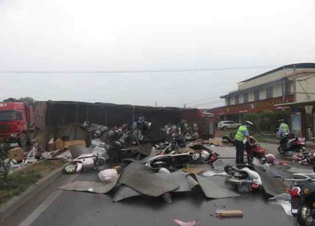 货车避电动车侧翻 大货车雨天路滑侧翻 62辆电动车散落在路上