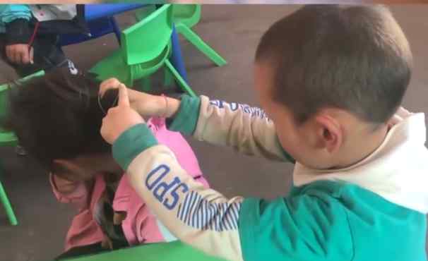 幼儿园男孩帮女同学扎丸子头 手法娴熟 网友：小暖男