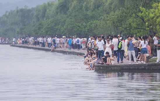 西湖成洗脚池 许多游客脱掉鞋袜泡脚或戏水