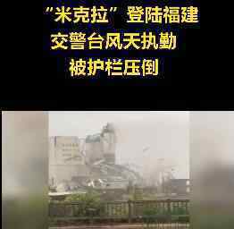 台风天执勤交警扶护栏被压倒 一定要注意安全