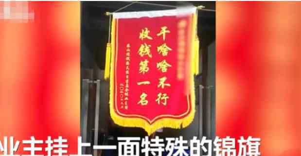 小区业主集体送物业锦旗挂楼道口 上面10个大字亮了