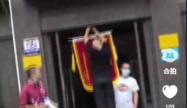 小区业主集体送物业锦旗挂楼道口 上面10个大字亮了