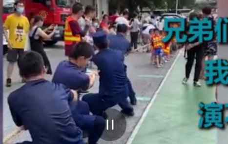 消防员和小朋友拔河 一本正经的放水