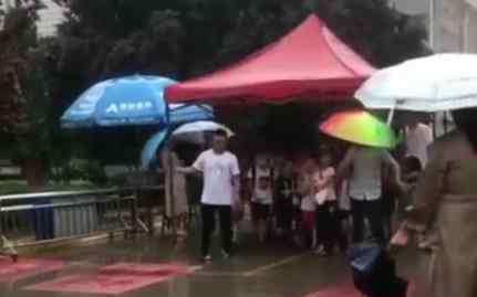 小学老师举雨棚护送学生放学 网友：像母鸡守护着小鸡