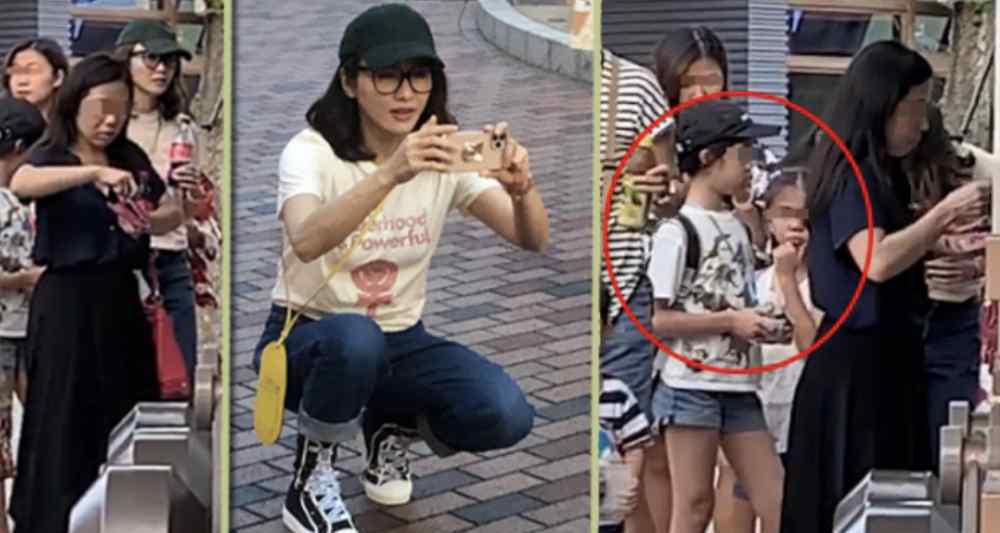 黎姿的孩子 黎姿带仨女儿到乐园玩，她蹲下为孩子拍照，大女儿拥有修长美腿