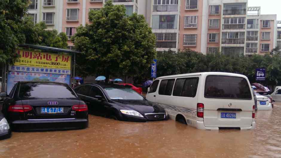 昆明遭遇暴雨 暖心小伙背行人过马路文章配图
