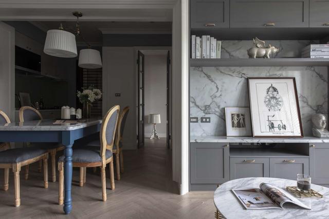 美式风格设计:孔雀蓝沙发搭配灰色护墙板,营造宁静的舒适环境